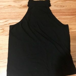 Sleeveless, high neck, black top.